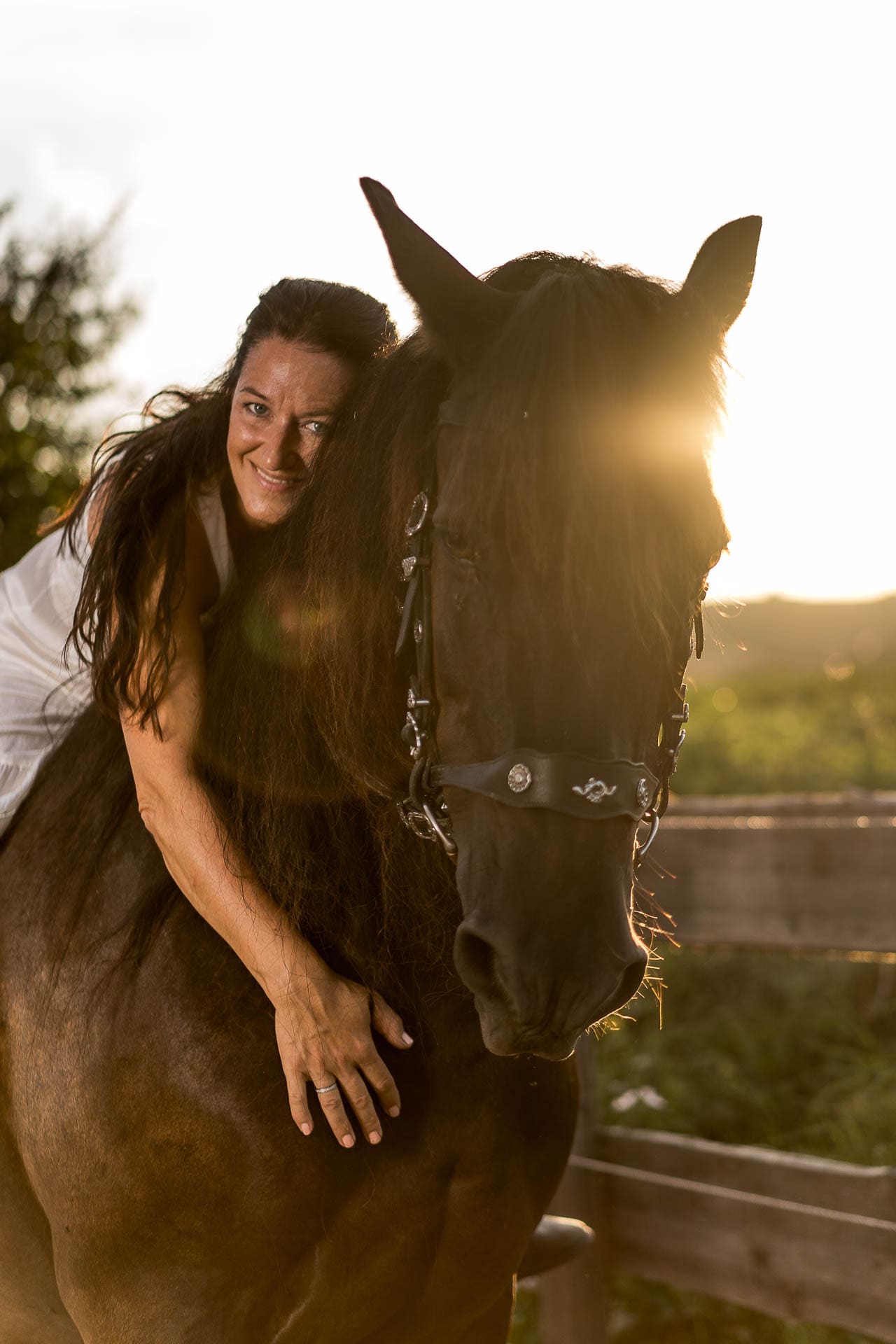 Frau auf Pferd im Sonnenuntergang.