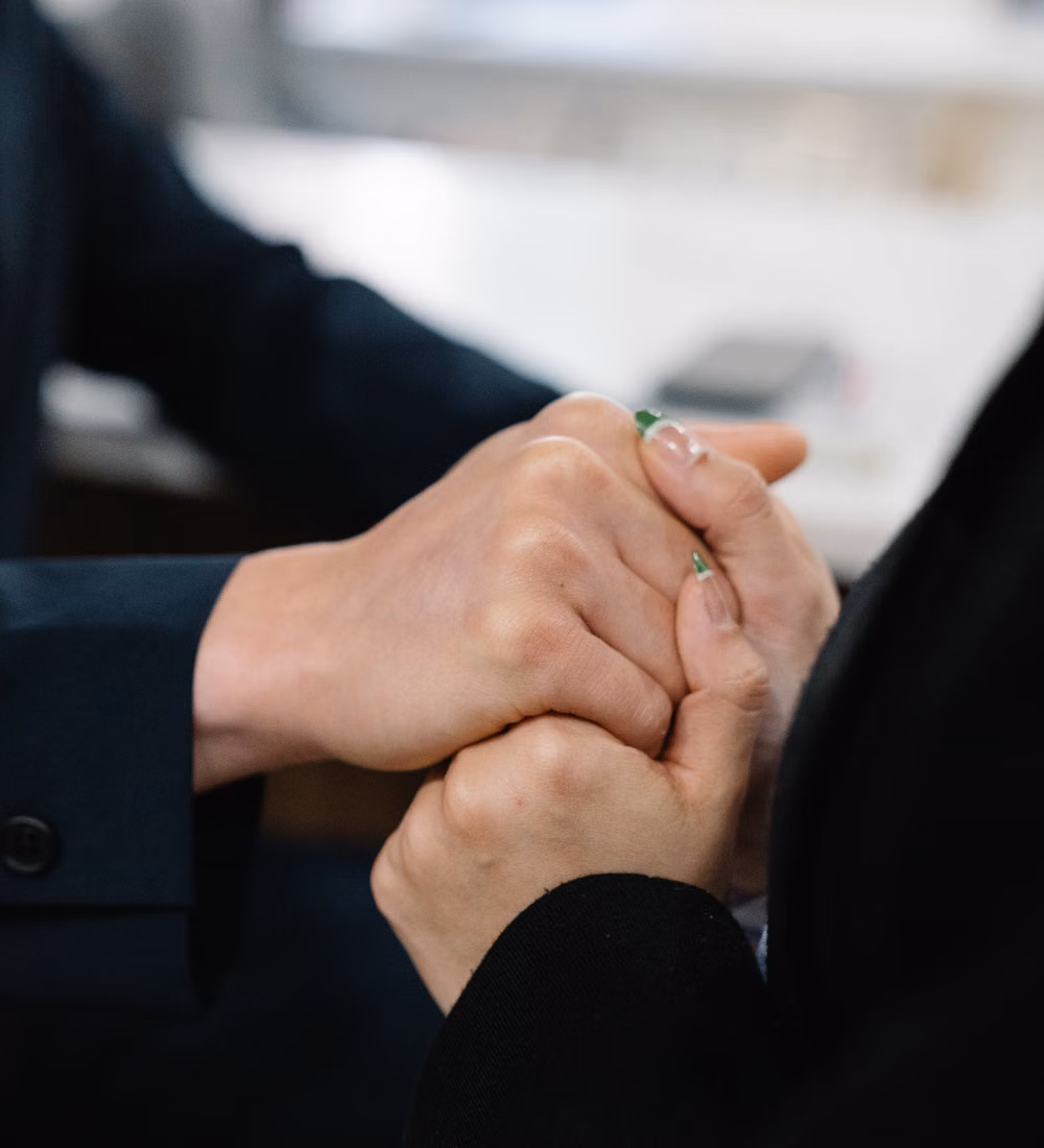 Zwei Personen halten einander an der Hand